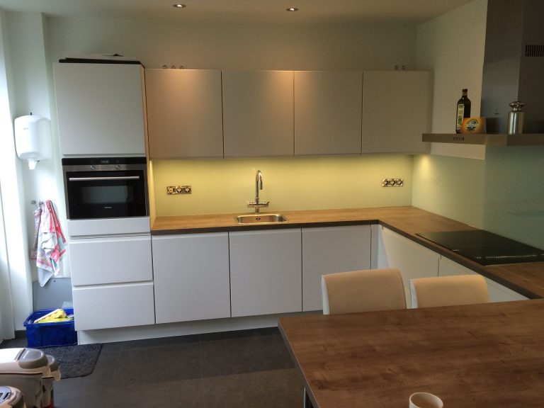 Witte keuken met houten werkblad en inbouwapparatuur